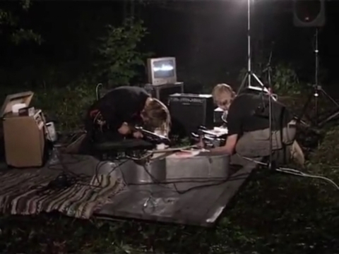Juozo Milašiaus ir Dariaus Čiutos nuotolinis performansas „Miško testas“ Nemenčinės miške ir Šiuolaikinio meno centre. 2004. Kadras iš videodokumentacijos
